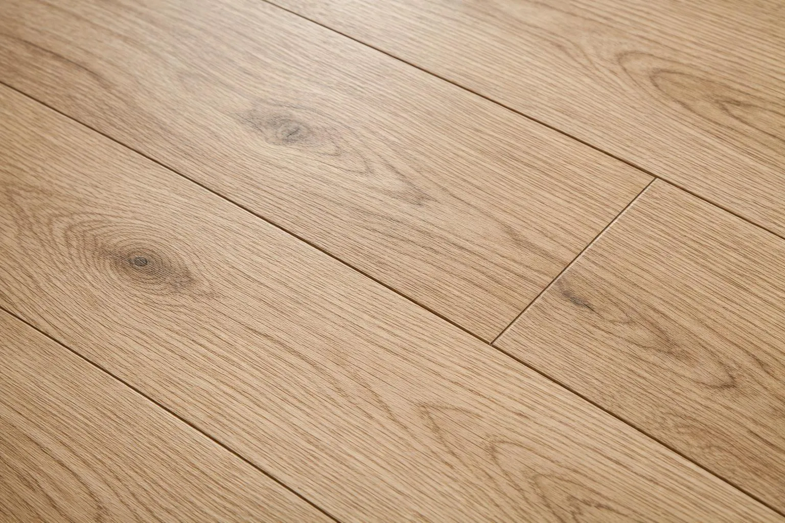 Modern kitchen with high-quality laminate flooring in light oak finish showing synthetic texture and realistic wood-grain pattern, bright natural lighting revealing surface layer details