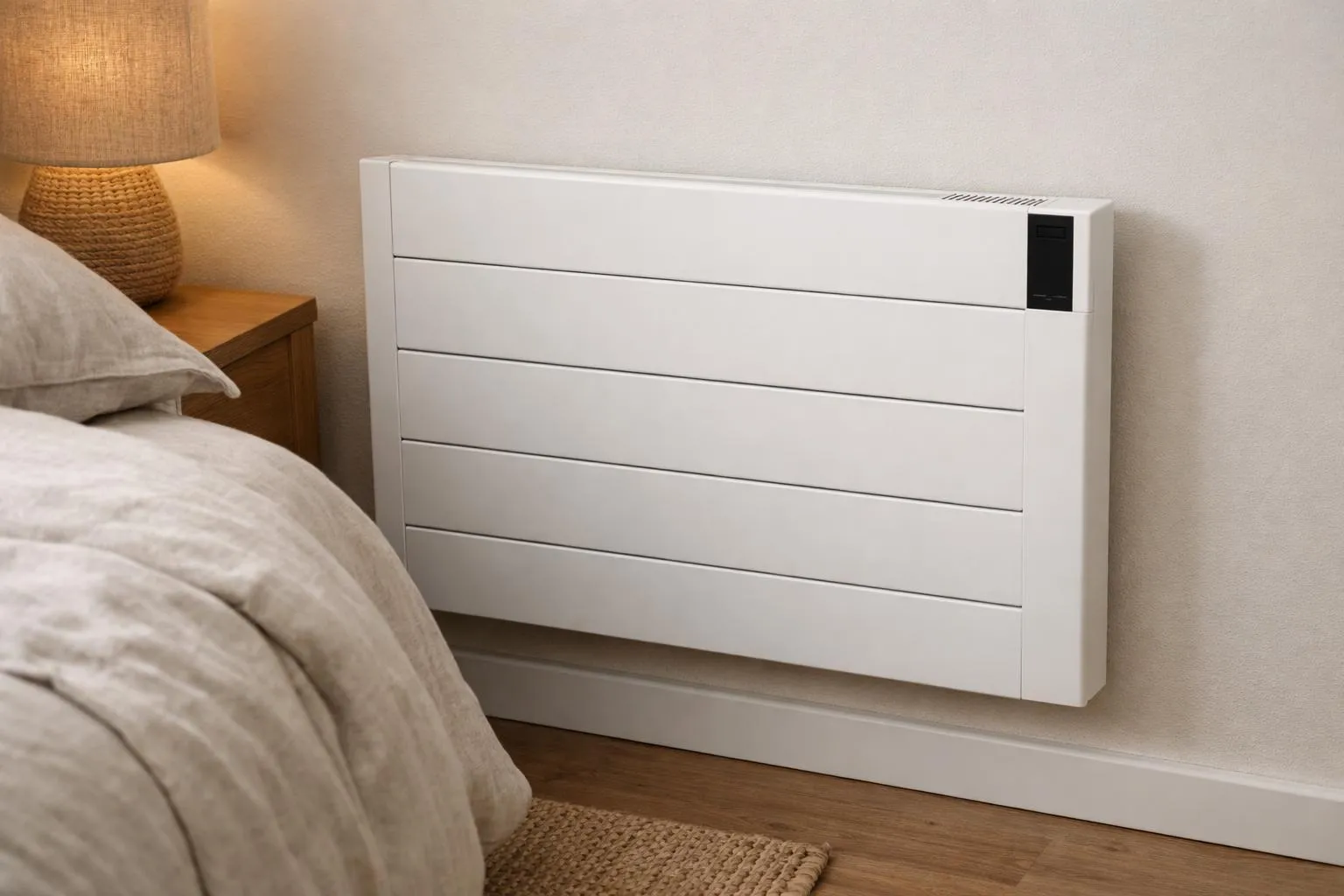Modern bedroom interior with a sleek wall-mounted inertia radiator beside a bed with neutral linens, warm lighting creating a cozy atmosphere, no visible text or labels on the radiator or walls, focus on the radiator's design and placement in a real residential setting